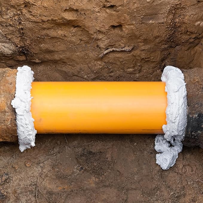 ESPUMA DE POÇOS S24 RECA | Vedação resistente para zonas húmidas Tubo amarelo entre tubagens com pasta branca em terra