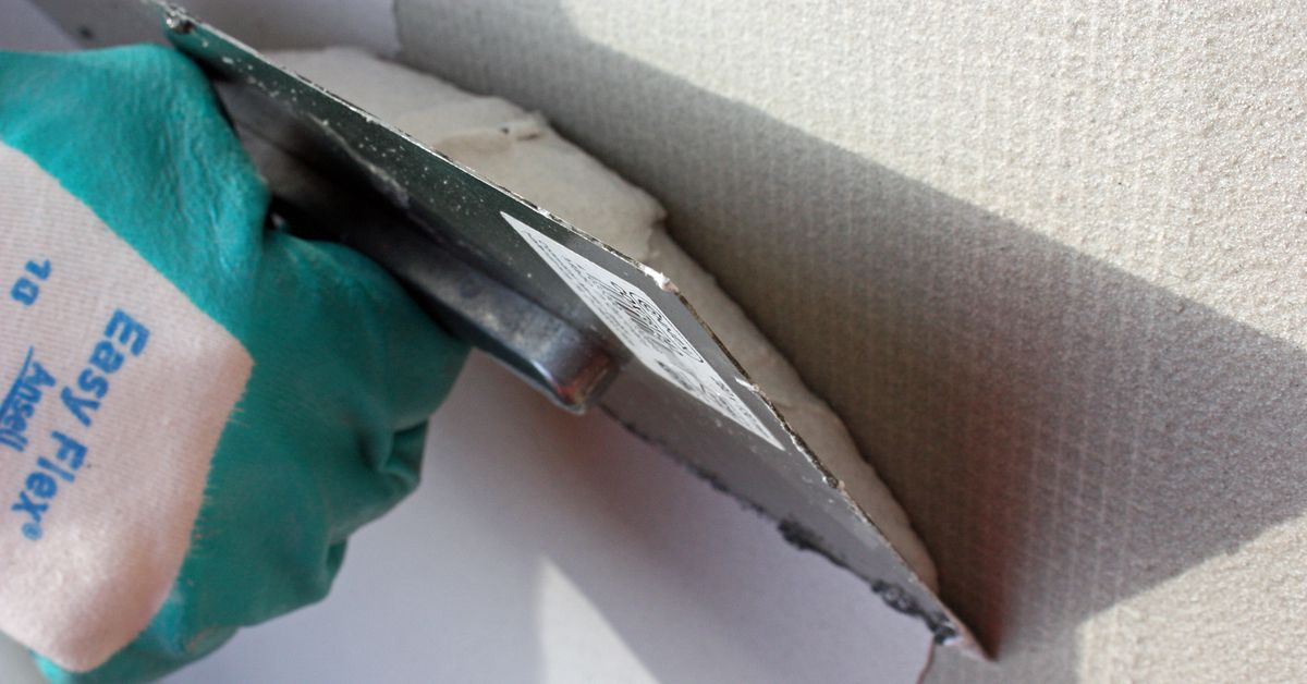 REMMERS MB1K Espátula metálica com luva a aplicar reboco em parede clara