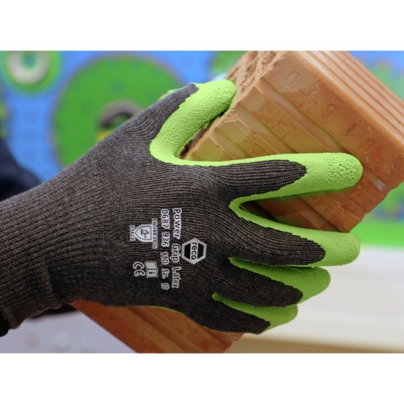 Luvas de Proteção Power Grip Latex Luva preta com pontas verdes segurando um tijolo