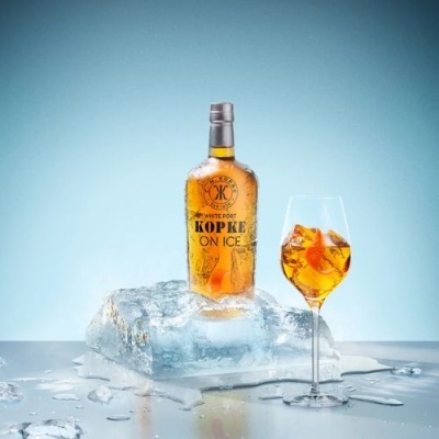 Garrafa de Kopke White Port ON ICE sobre gelo com copo de bebida gelada e laranja
