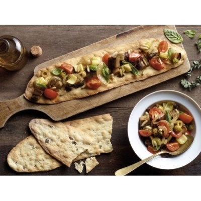 Pão focaccia com vegetais variados servidos numa tábua de madeira e prato branco com salada de vegetais em azeite