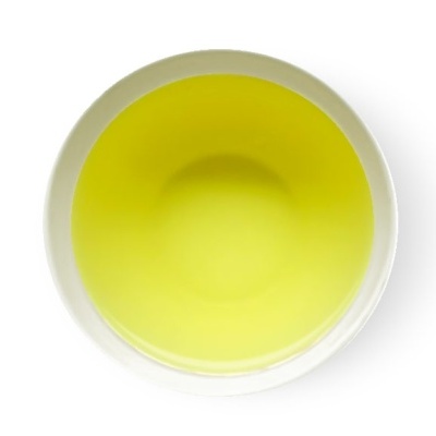 Prato branco visto de cima com líquido amarelo no centro