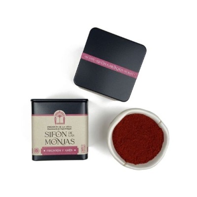 Embalagem preta com rótulo creme e recipiente branco com pó vermelho