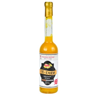 Garrafa de molho picante amarelo com rótulo branco e tampa dourada