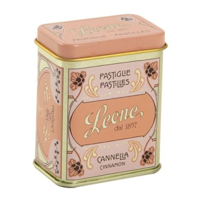 Lata metálica rosa com detalhes dourados e texto 'Leone dal 1857 Cannella Cinnamon'