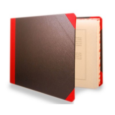 Livro/álbum com capa preta e vermelha aberto sobre fundo branco