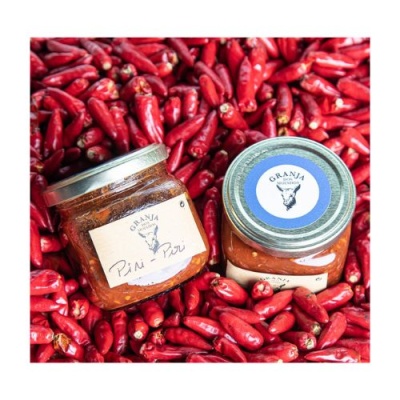 Frascos de molho Piri-Piri rodeados de piri-piris vermelhos