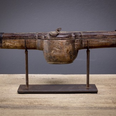 Estojo antigo de madeira rústica num suporte metálico