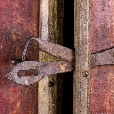 Fechadura de metal enferrujada em portas de madeira vermelha envelhecida