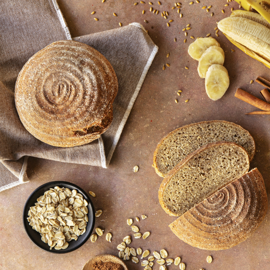 Pão de Banana e Canela 300g - Pachamama Pão integral redondo com textura espiral, fatias, aveia, banana e canela