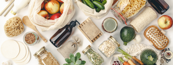 As Vantagens de Comprar a Granel Produtos naturais e sustentáveis numa mesa clara, com frutas, vegetais, frascos e utensílios ecológicos