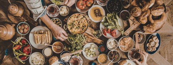 Mesa posta com comida variada em pratos e cestos de madeira