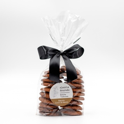 Pacote transparente de bolachas tradicionais com laço preto e etiqueta alecrim dourado