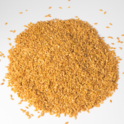 Sementes douradas em pilha sobre fundo branco