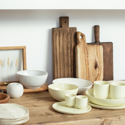 Conjunto de cerâmica creme e tábuas de madeira sobre mesa rústica