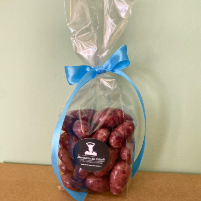 Pacote transparente com amêndoas vermelhas com fita azul e etiqueta preta