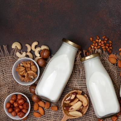 Frascos de leite com várias nozes e castanhas sobre tela de juta.