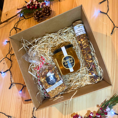 Caixa de presente com mel, granola e tisana em embalagem de cartão com decoração natalícia