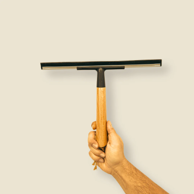 Rodo com cabo de madeira numa mão