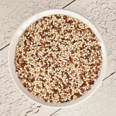 Mistura de quinoa branca, vermelha e preta numa tigela branca.
