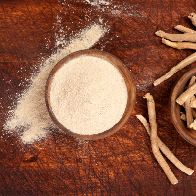 Pó branco fino em tigela de madeira com raízes secas ao lado sobre tábua de madeira
