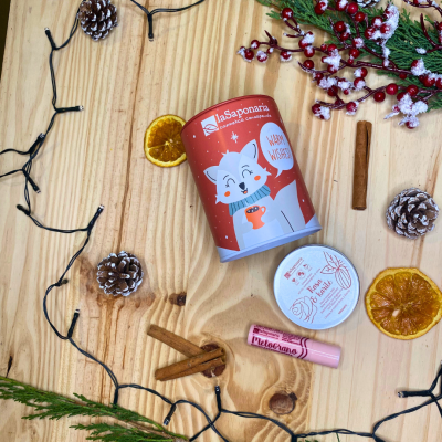 Frasco vermelho de cosmética natural, lip balm e decoração natalícia sobre fundo de madeira