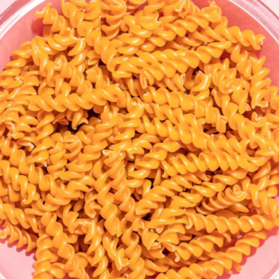 Massa fusilli laranja crua num recipiente transparente
