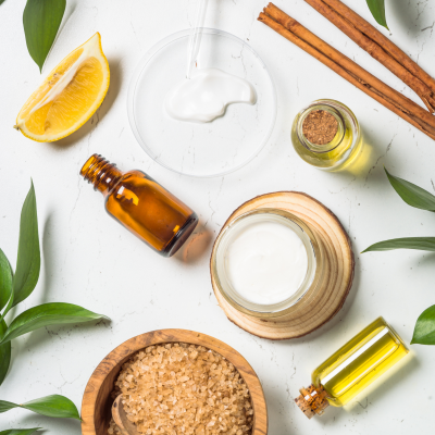 Produtos naturais de cuidado de pele com creme, óleo, canela, limão, sal grosso e folhas verdes