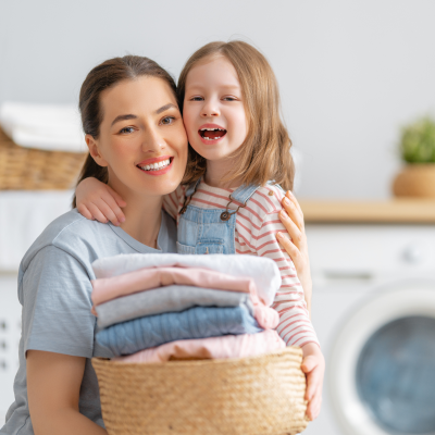 Mulher e menina com cesto de roupa na lavandaria