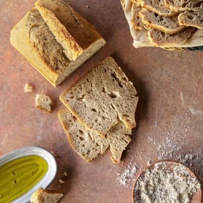 Fatias de pão artesanal e azeite sobre superfície de pedra