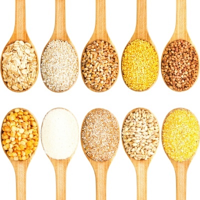 Dez colheres de pau com cereais e grãos variados sobre fundo branco
