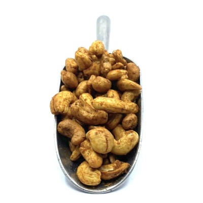 Colher de metal cheia de castanhas de caju torradas