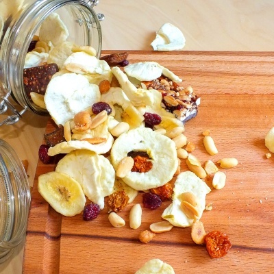 Frutos secos variados em tábua de madeira com frascos de vidro