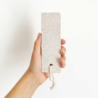 Segurando retângulo claro com textura granular e cordão branco em fundo branco