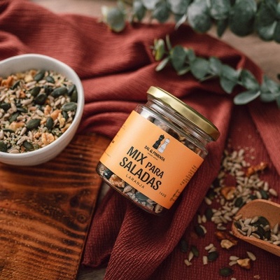 Frasco de mistura para saladas com recipiente e colher sobre tecido vermelho