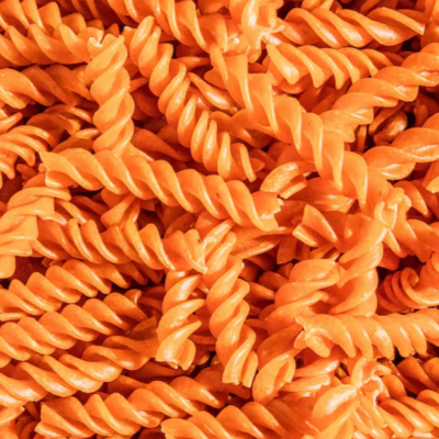 Massa fusilli laranja vibrante com textura rugosa