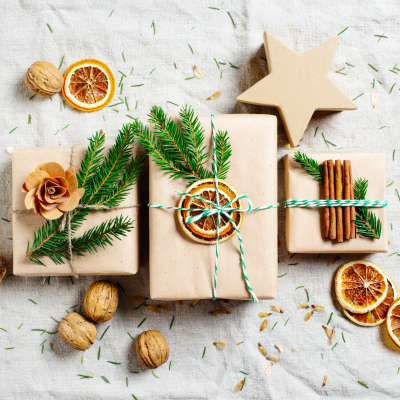 Presentes embalados com elementos naturais sobre tecido bege