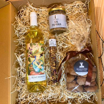 Conjunto de produtos gourmet em caixa de papelão com palha decorativa