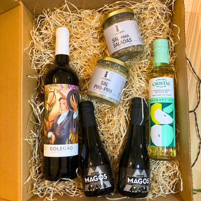Conjunto de vinhos, sal aromatizado e vinagre em caixa de presente com enchimento de palha.