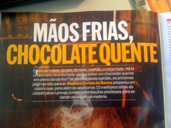 Página com texto 'MÃOS FRIAS, CHOCOLATE QUENTE' sobre fundo escuro com vapor