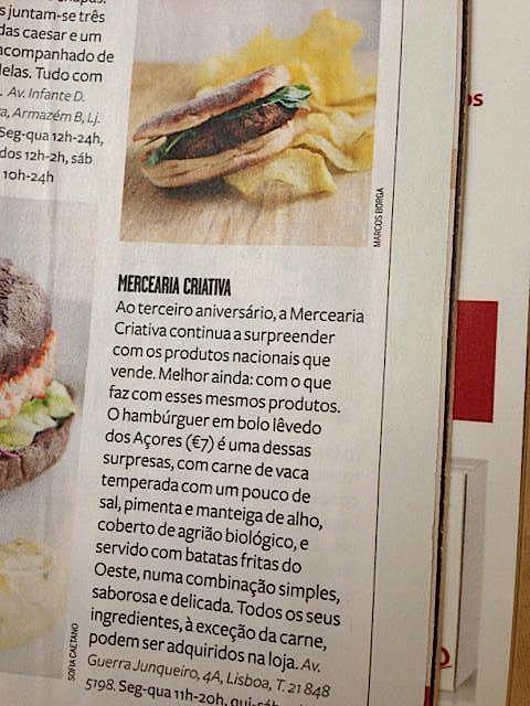 Hambúrguer em pão chato com batatas fritas ao fundo e texto descritivo em português.