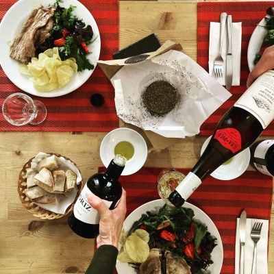 Mesa posta com pratos de comida, pão, vinho e copos