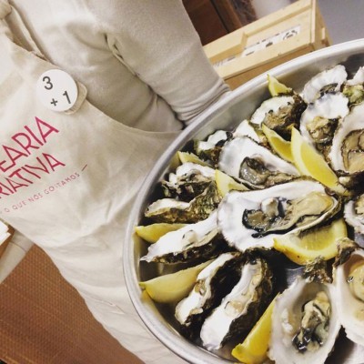 Tabuleiro com ostras frescas abertas e fatias de limão