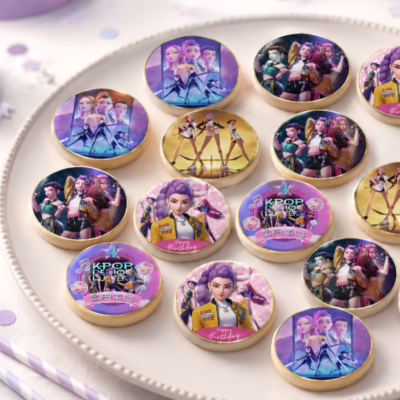 Bolachas redondas decoradas com imagens de personagens femininas e texto aniversariante