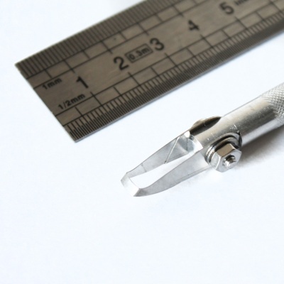 ferramenta metálica com lâmina afiada e régua metálica com marcações