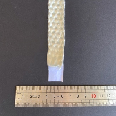 Fita trançada branca com base transparente e régua de metal num fundo preto