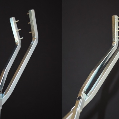 Ferramentas metálicas prateadas com duas pernas e pontas na extremidade superior