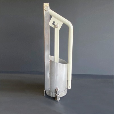 Instrumento metálico prateado com alças brancas sobre superfície escura.