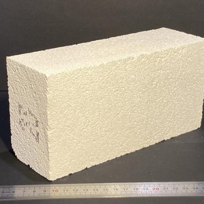 Bloco de construção bege com textura porosa e régua ao lado