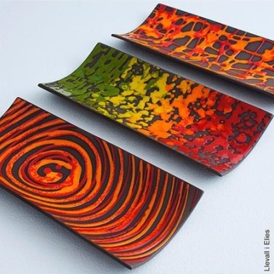 Três pratos retangulares coloridos com padrões abstratos vibrantes